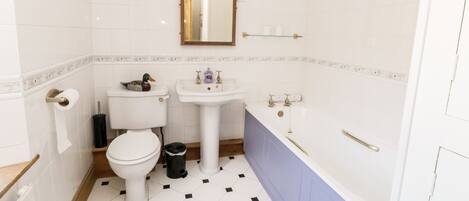 A bathroom with a toilet, sink, and bathtub.