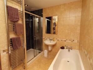 Une salle de bain avec une douche à parois de verre, un lavabo et une baignoire.