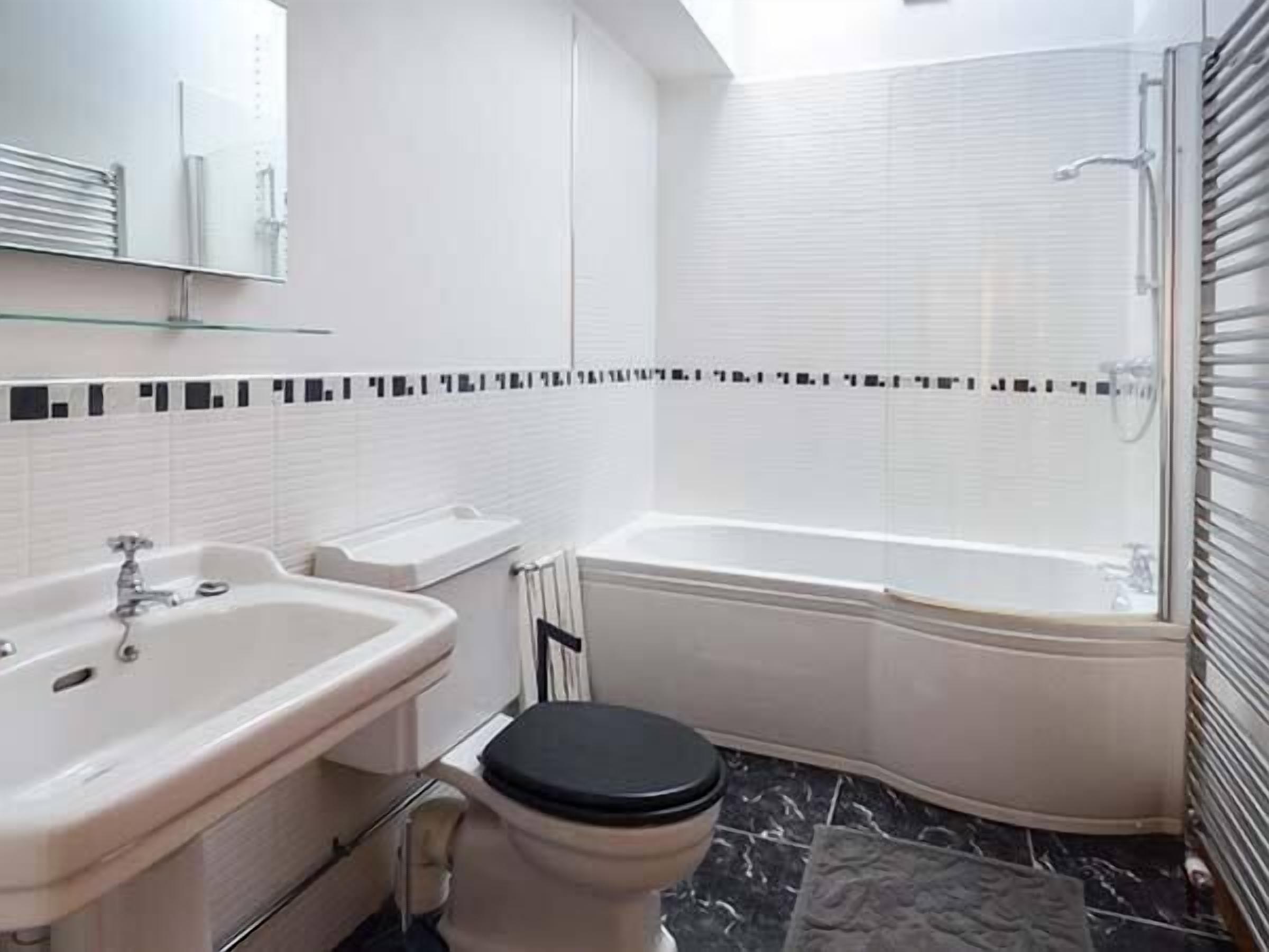 Un baño con lavamanos, inodoro y bañera.