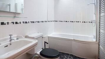 Un baño con lavamanos, inodoro y bañera.