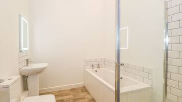 A bathroom with a toilet, sink, and bathtub.