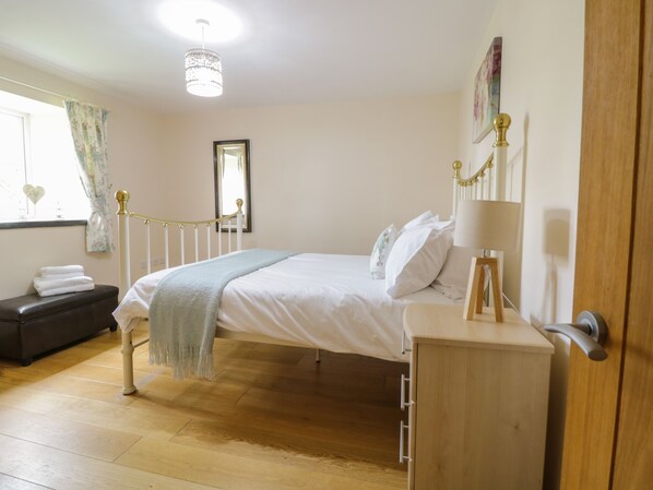 Une chambre à coucher avec un lit, une table de chevet et une armoire.