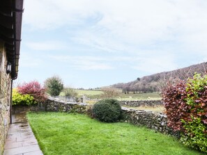 Escape to a serene countryside retreat with a traditional stone building and rolling hills.