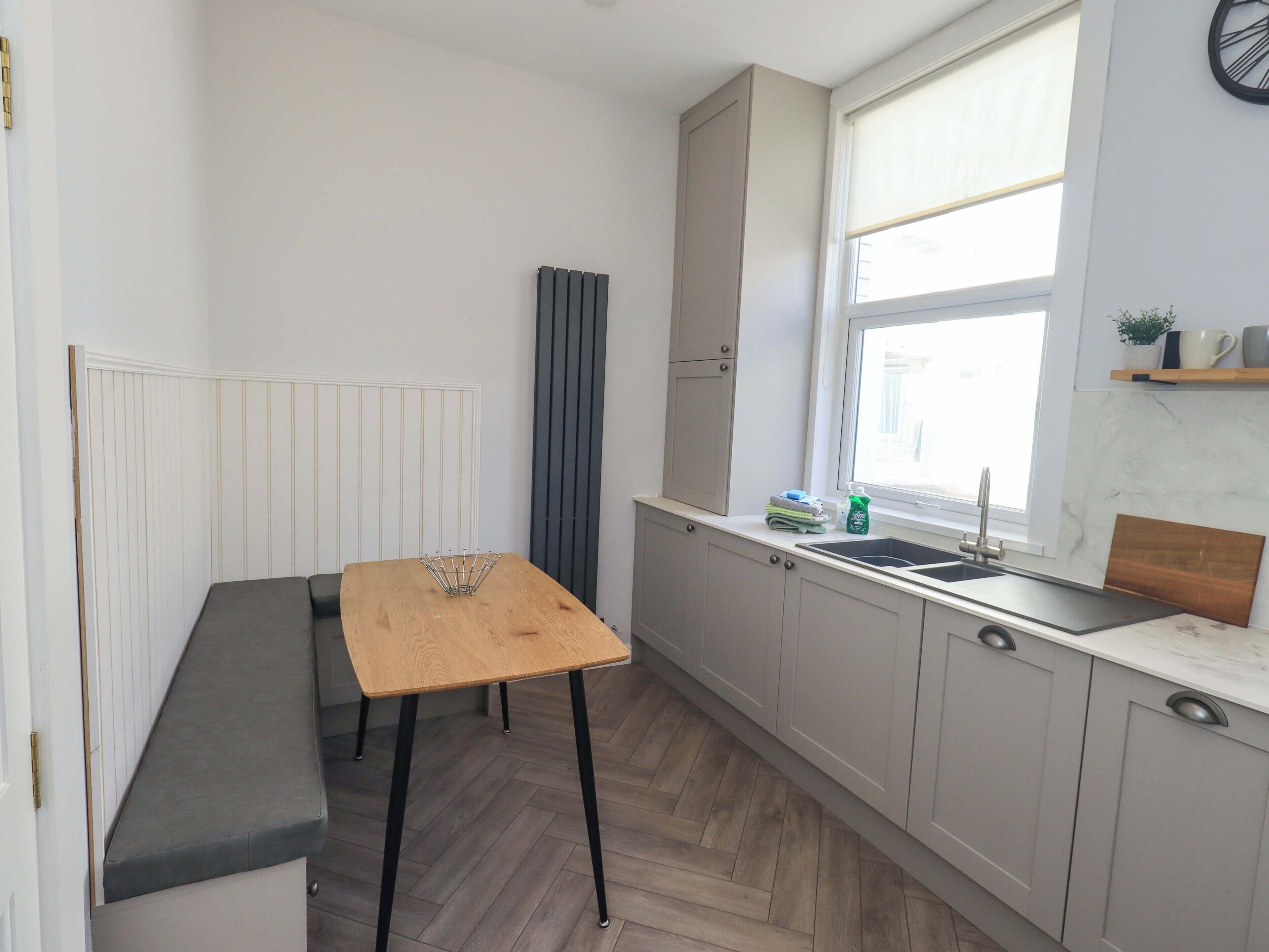 Eine kleine Küche mit Holztisch, Bank und einem Fenster mit Blick.