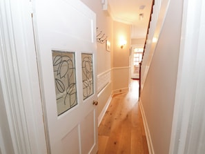 Stylish hallway with a door featuring a floral glass panel and a brass doorknob.