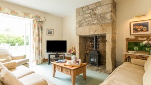 Una sala de estar acogedora con chimenea de piedra, televisor y asientos cómodos.