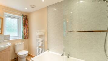 A modern bathroom with a bathtub, toilet, and sink.
