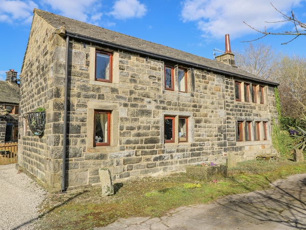 A stone building with multiple windows and a chimney.