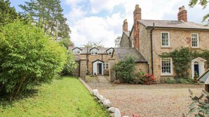 A stone building with a gravel driveway and a grassy area.