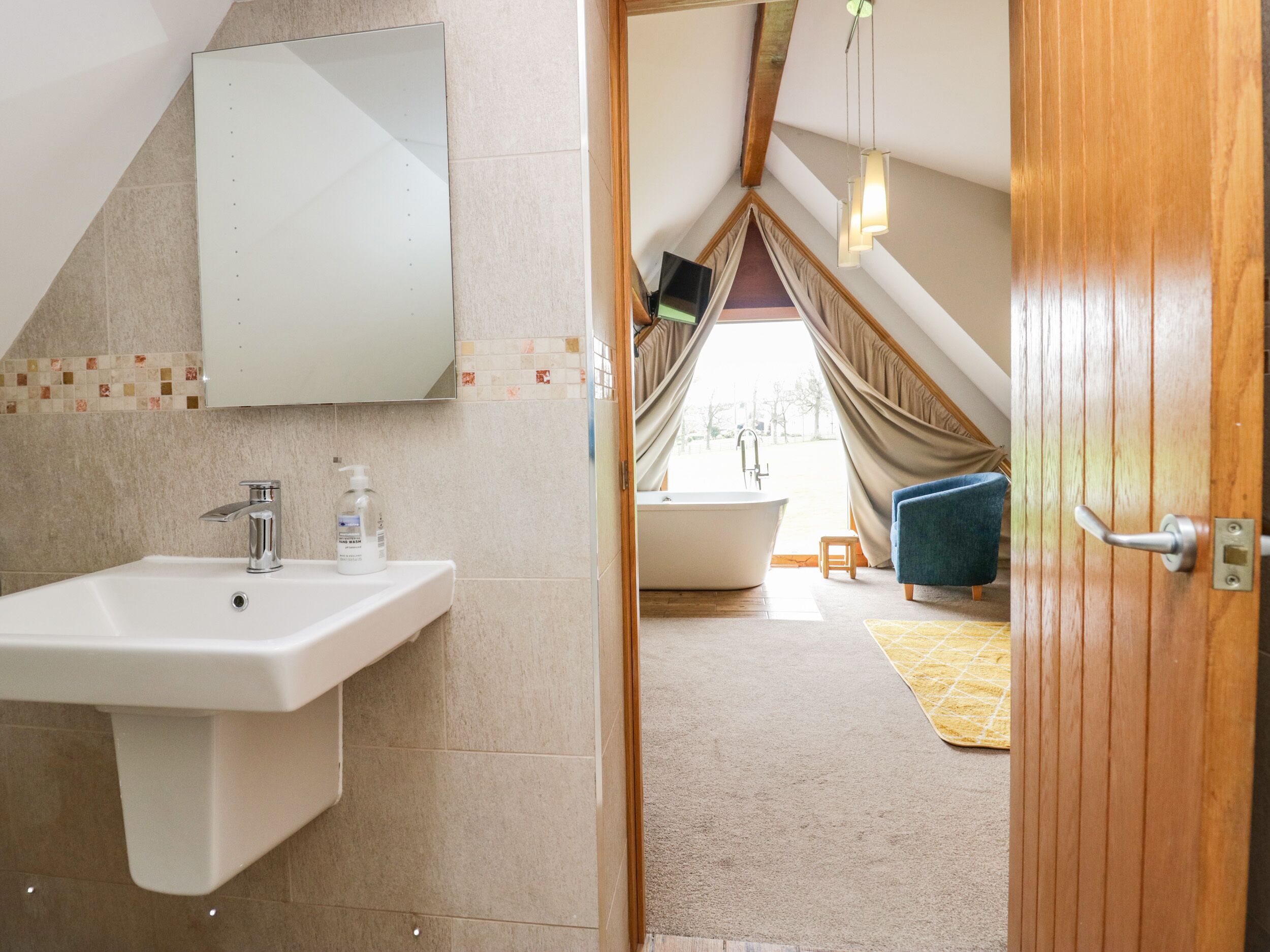 Une salle de bain moderne avec un lavabo, un miroir et une baignoire.