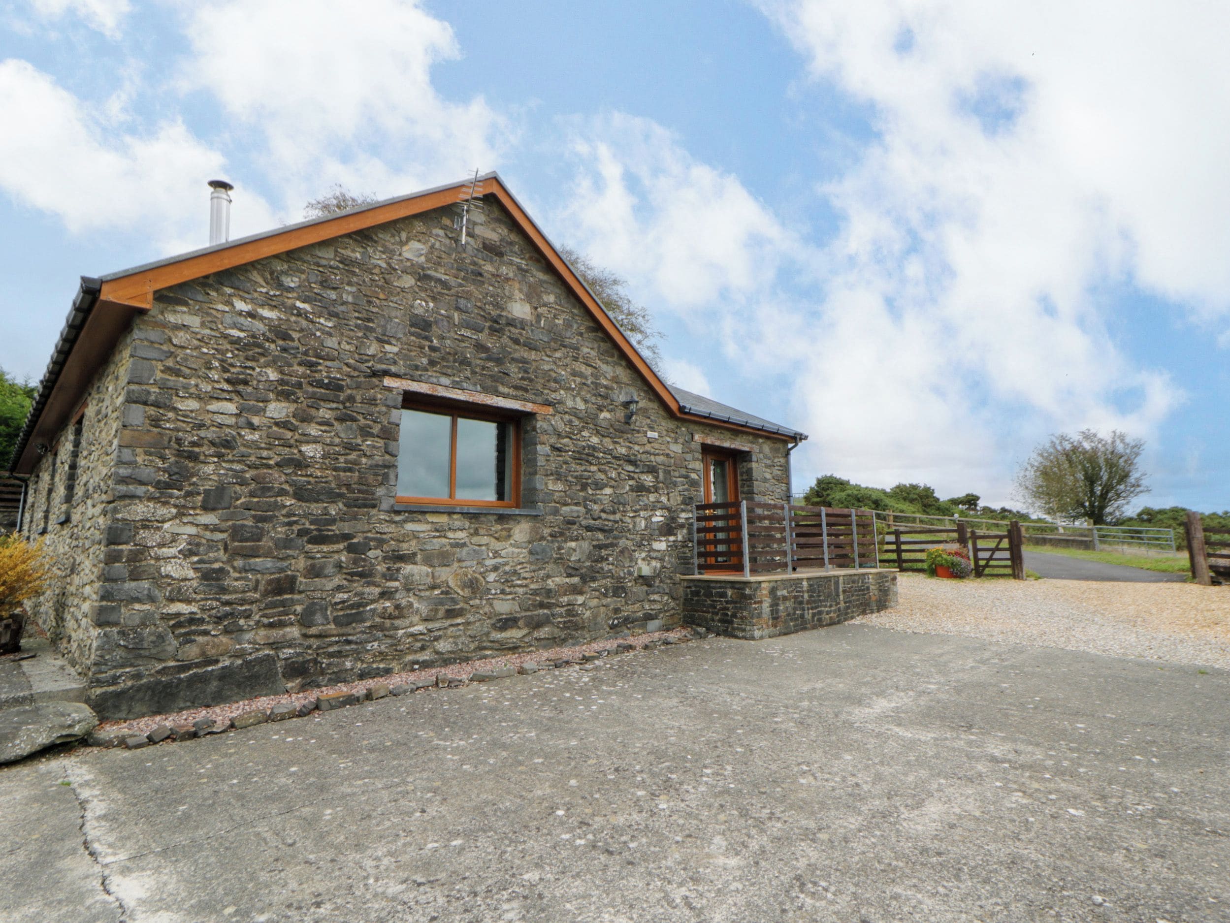 A stone building with a sloped roof, a small window, and a wooden door.