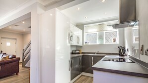 Una cocina moderna con armarios blancos, electrodomésticos de acero inoxidable y una isla grande.