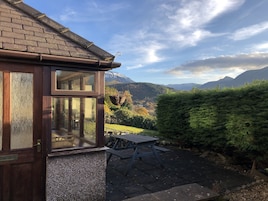 Una casa de madera con ventana y vistas a las montañas.
