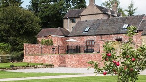 A brick building with a paved driveway and a lawn. - Manor Barn (Stoke-on-Trent)