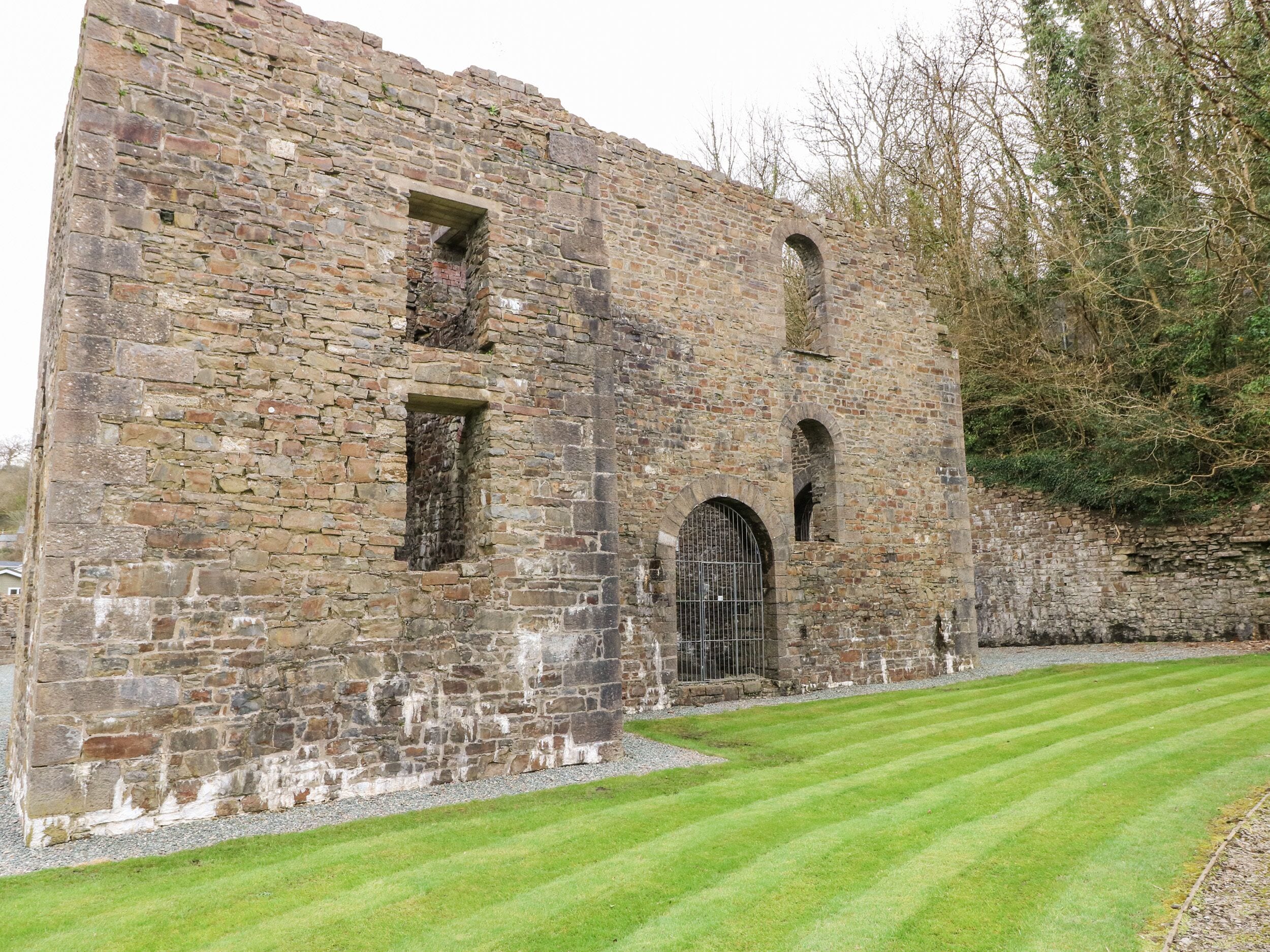 An old stone building with arched windows and a gated entrance.