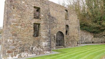 An old stone building with arched windows and a gated entrance.