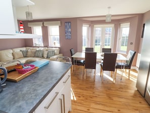 Enjoy meals in the kitchen with a central island and dining area featuring a table for four and a large window with an outdoor view.
