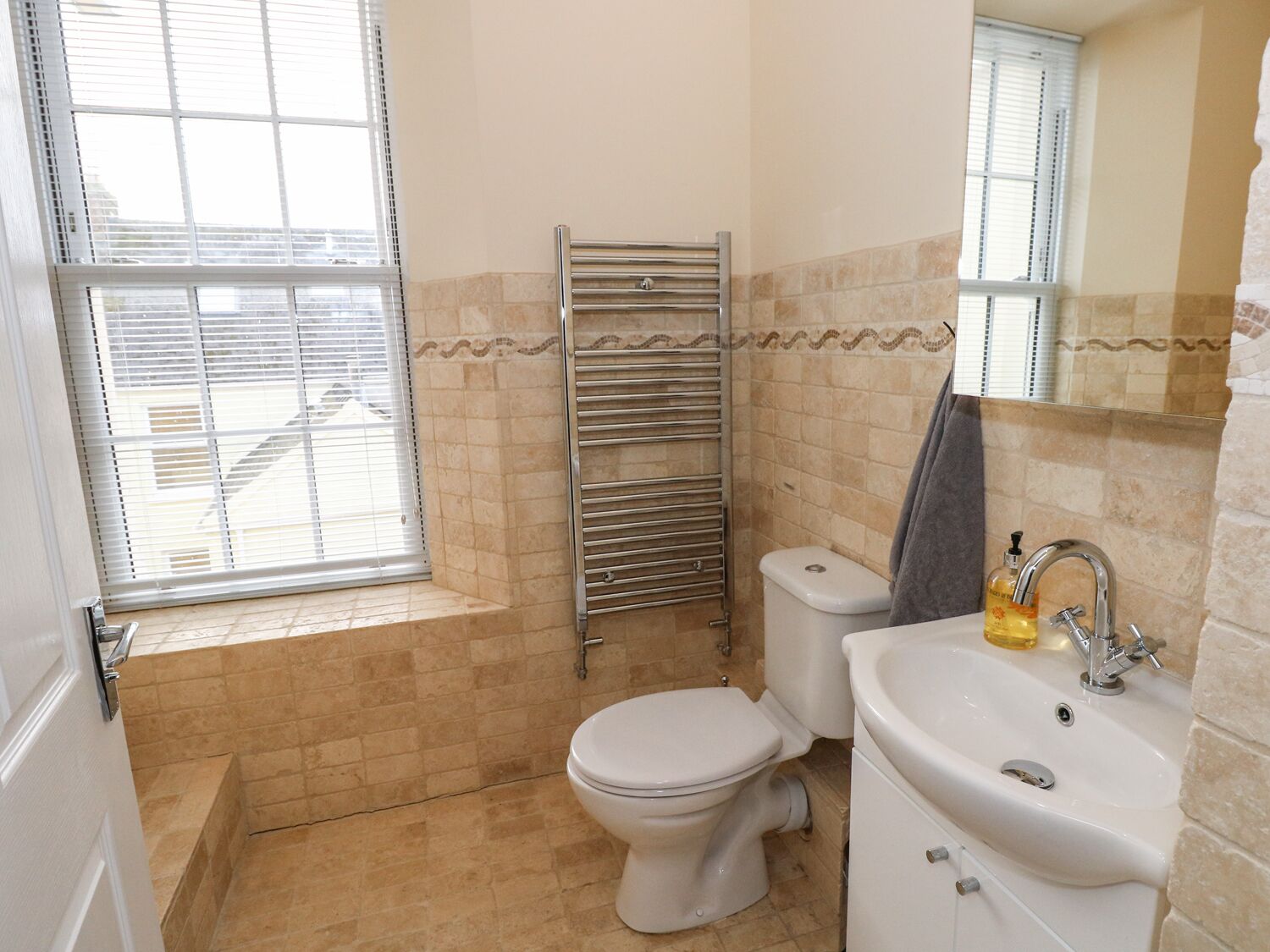 Een badkamer met toilet, wastafel en handdoekhouder.