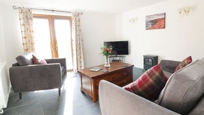 Una sala de estar con un sofá, una mesa de centro, un televisor y una chimenea.