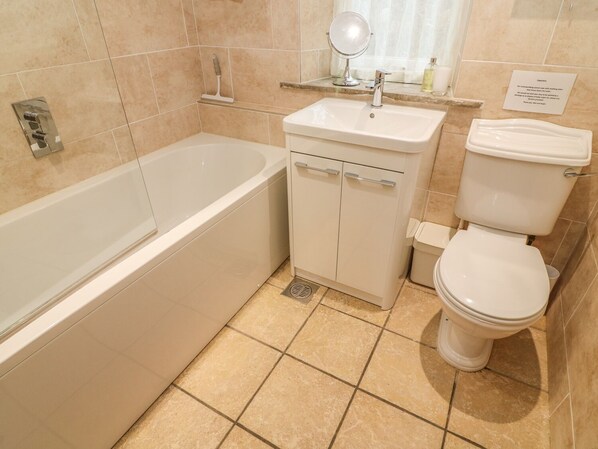A modern bathroom with a bathtub, sink, and toilet. - The Old Stables (Carnforth)