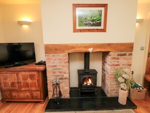 A living room with a fireplace, a television, and a cabinet.
