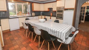 A kitchen with a dining table, chairs, and appliances. - The Old Barn (Stoke-on-Trent)