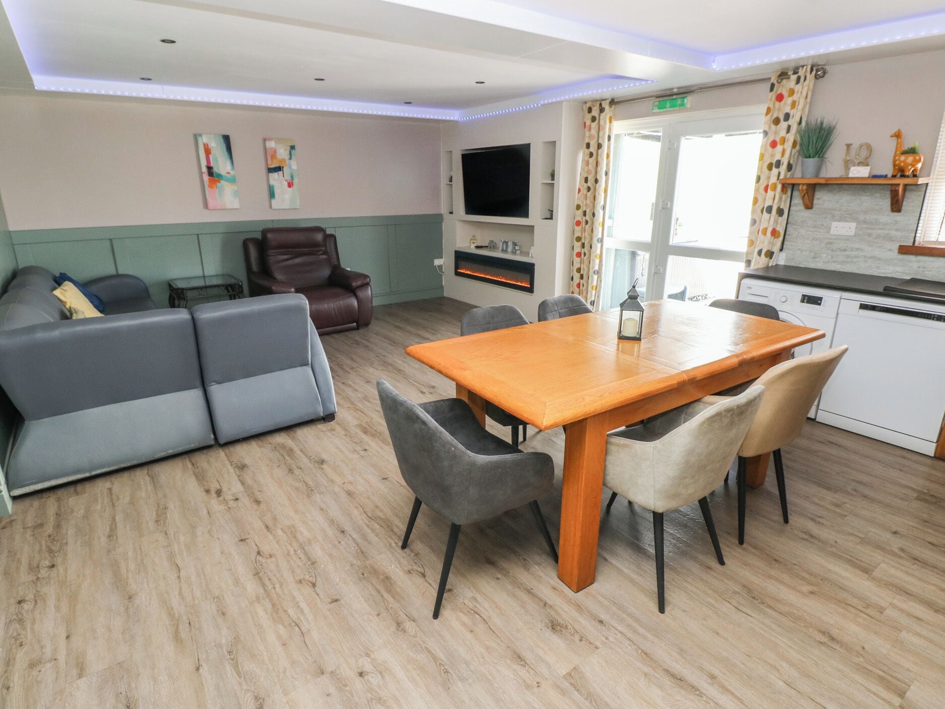 Un salon moderne avec un canapé, une table à manger et un téléviseur.