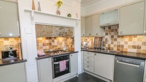 A modern kitchen with a gas stove, oven, and dishwasher. - Riverside View (Grange-over-Sands)