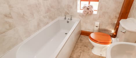 A bathroom with a bathtub, toilet, and sink.