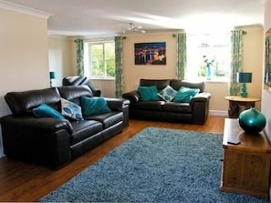 Relax in this stylish living room with two sofas, a shag rug, and a beautiful painting.