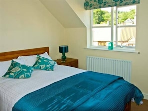 Relax in this cozy loft-style room with a comfortable bed, nightstand, and window with a beautiful view.