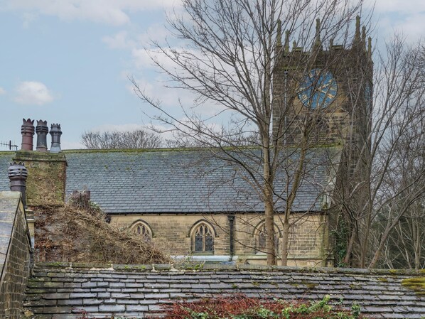 Una iglesia histórica con tejado de pizarra, ventanas de arco y una torre del reloj.