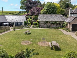 A well-maintained garden with a picnic table and a small play area. - The Old Stables (Blandford Forum)