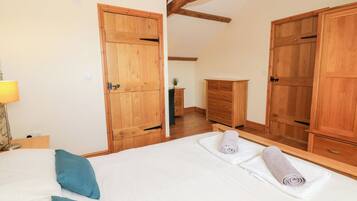 Une chambre à coucher comprenant un lit, deux armoires en bois, une commode et une lampe.