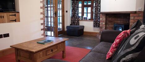 Una sala de estar con una mesa de centro de madera, un sofá, un televisor y una chimenea.