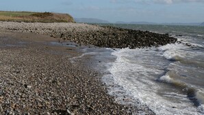 Una playa rocosa con olas rompiendo en la orilla.