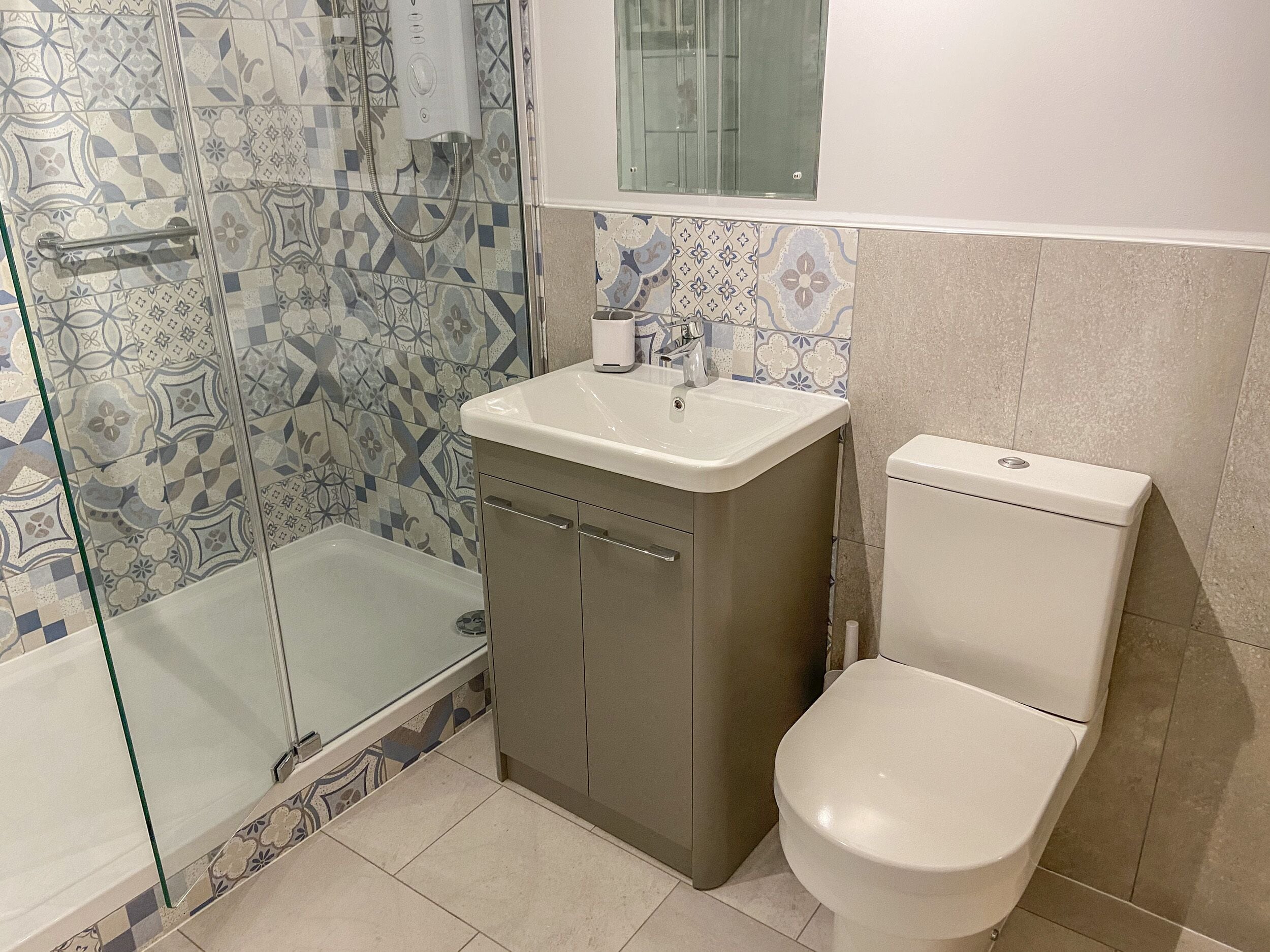 Ein Badezimmer mit Dusche, Toilette und Waschbecken.