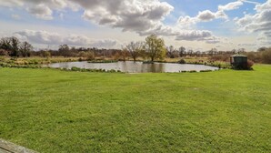 A grassy field with a pond and a gazebo. - Hayloft Cottage (Woodbridge)