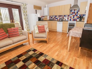 Cozy living space with a sofa set, armchair, and dining table.
