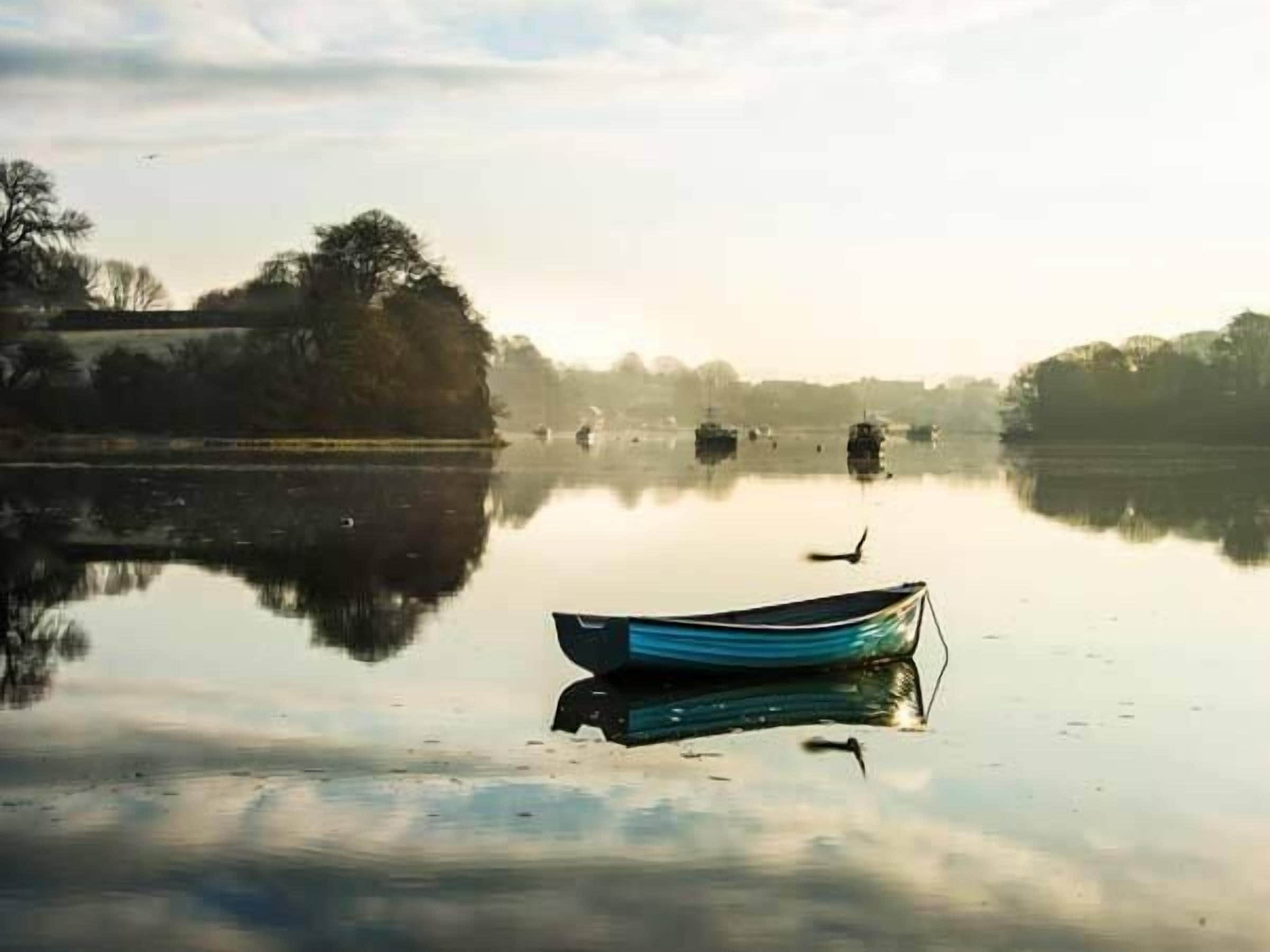 Un lac paisible, avec un seul bateau ancré au milieu.