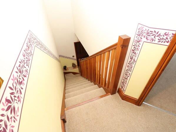 A carpeted staircase with wooden handrails and decorative panels on the walls. - Holly Lodge (Appleby-in-Westmorland)