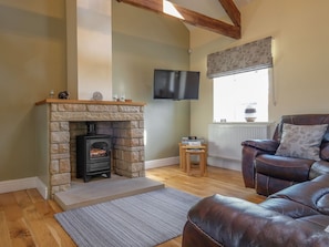 Relax in this inviting living room with a fireplace, comfortable sofa, and TV.