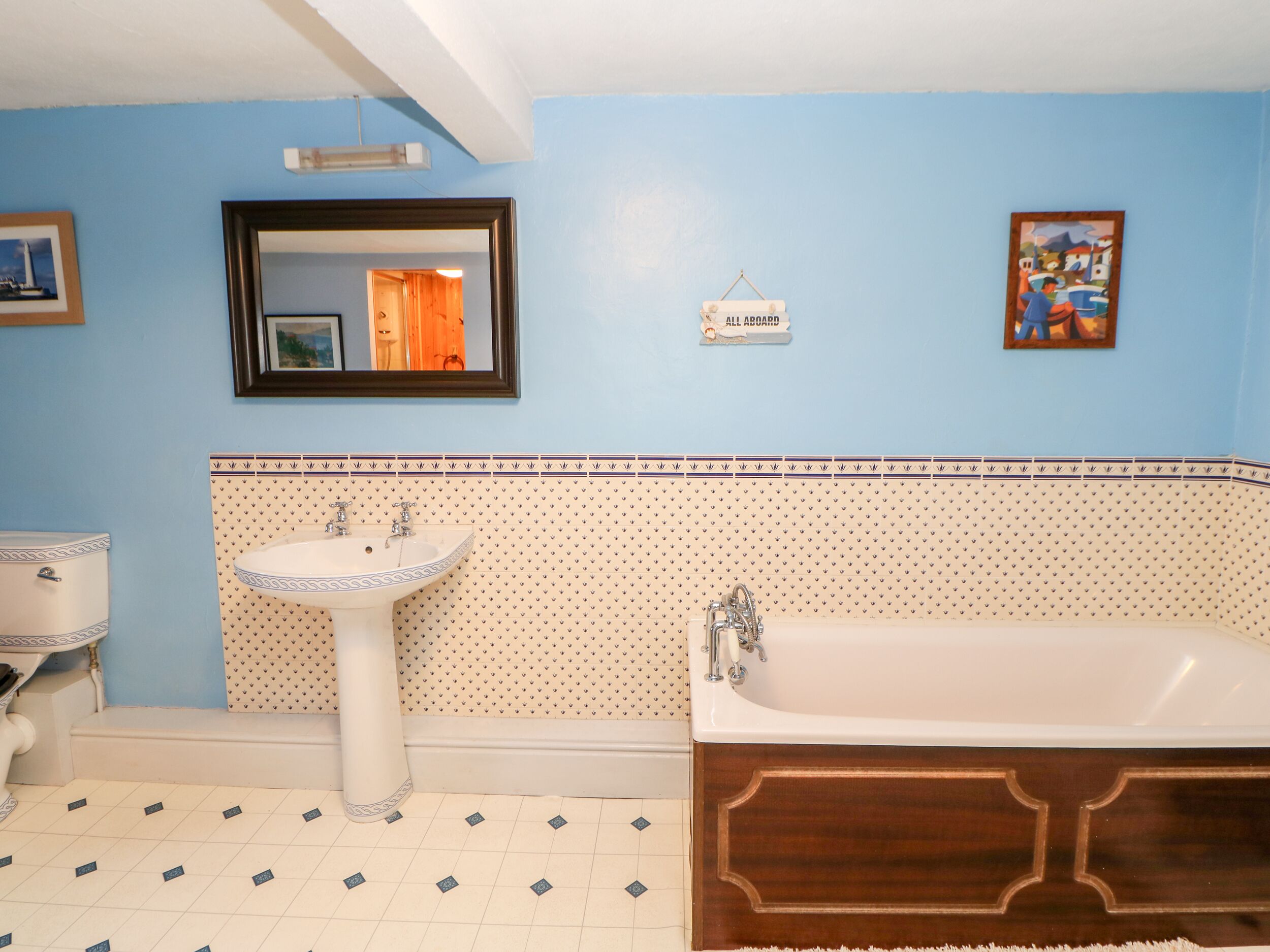 Une salle de bain avec un lavabo, une baignoire et un miroir.