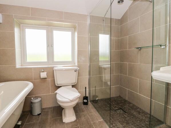 Un baño con inodoro, cabina de ducha de cristal y bañera.