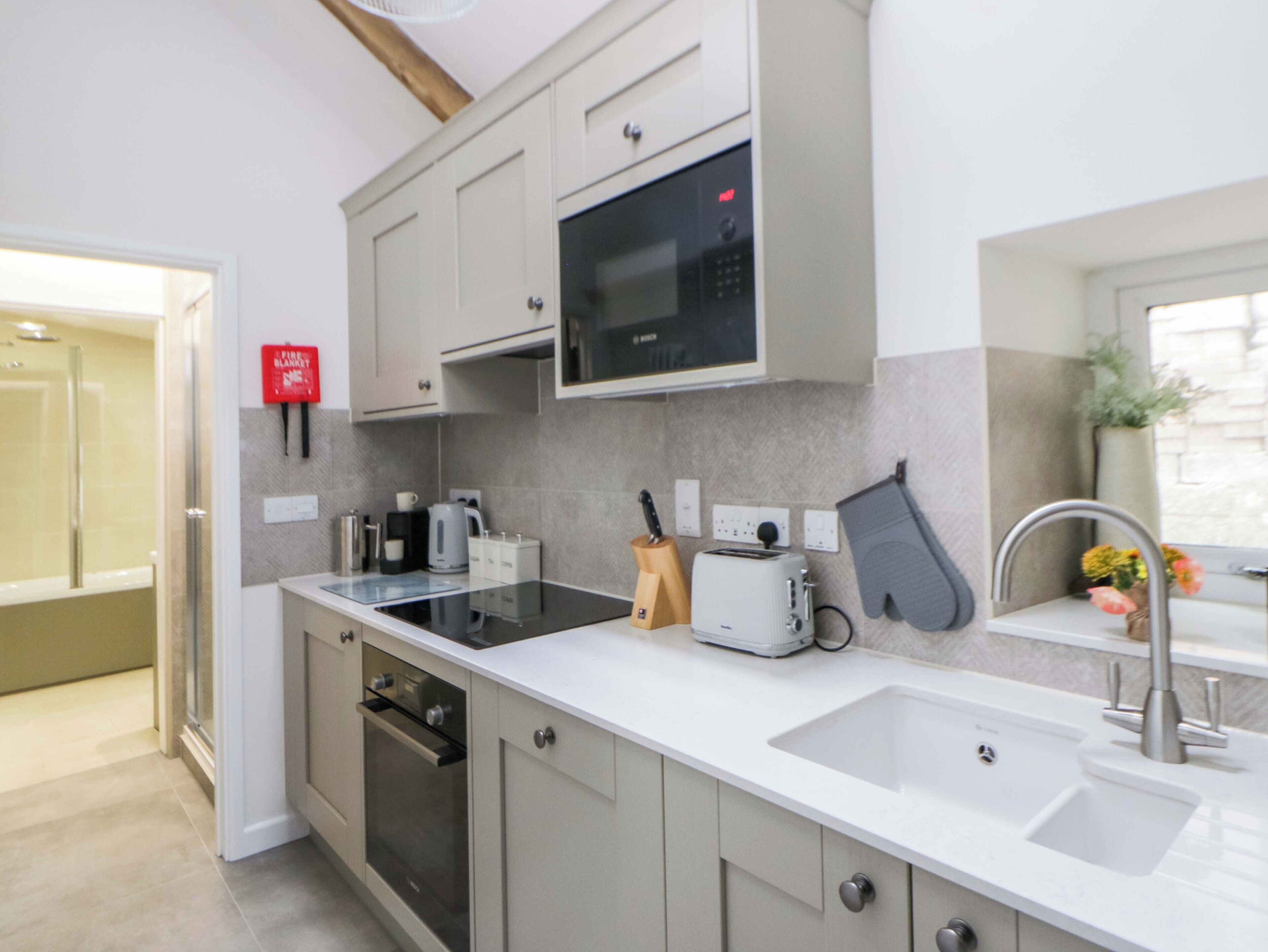 A modern kitchen with a microwave, toaster, and oven.