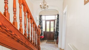 Una escalera de madera que lleva a una puerta con vistas al exterior.