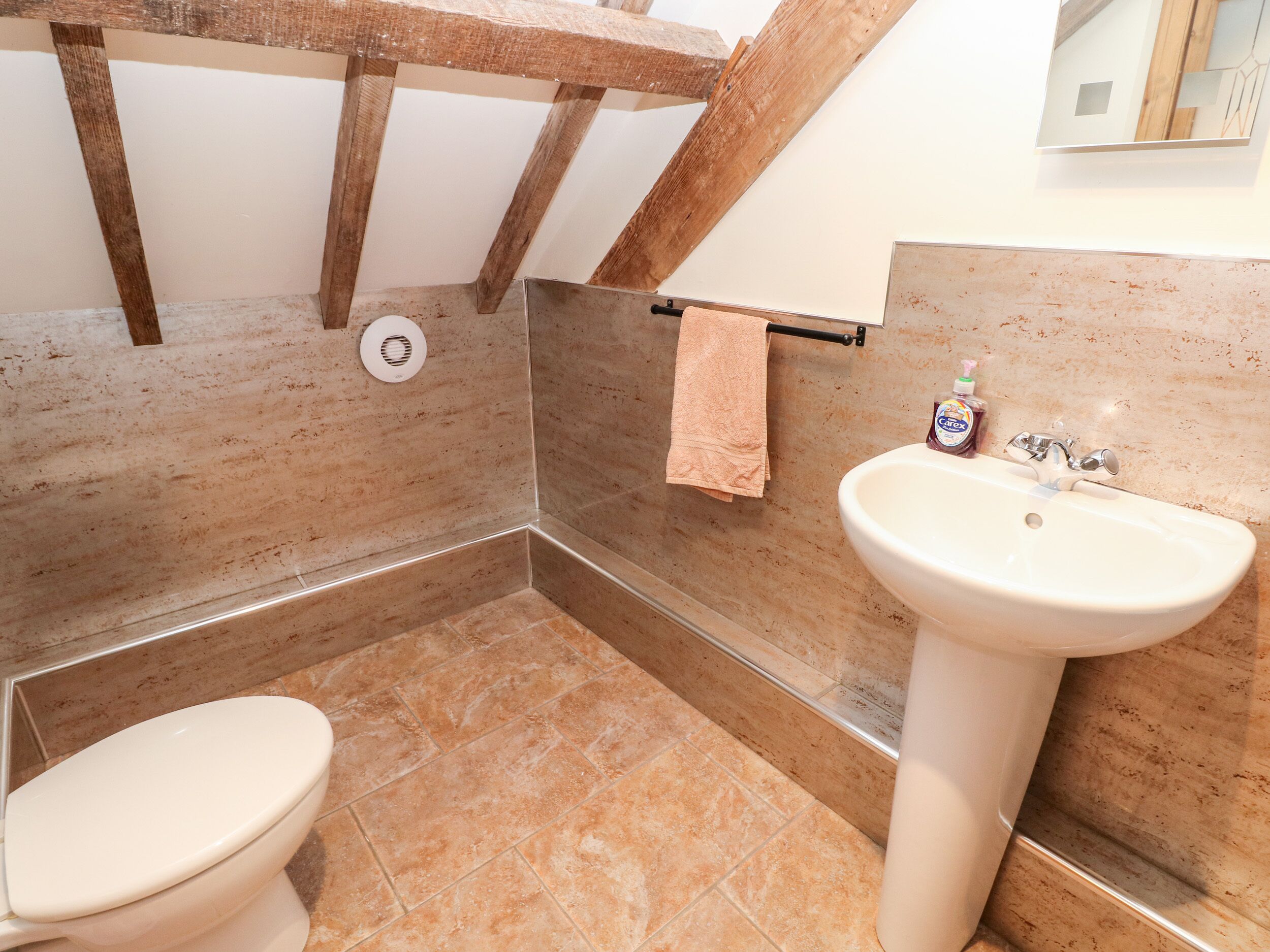 A bathroom with a toilet, a sink, and a shower area.