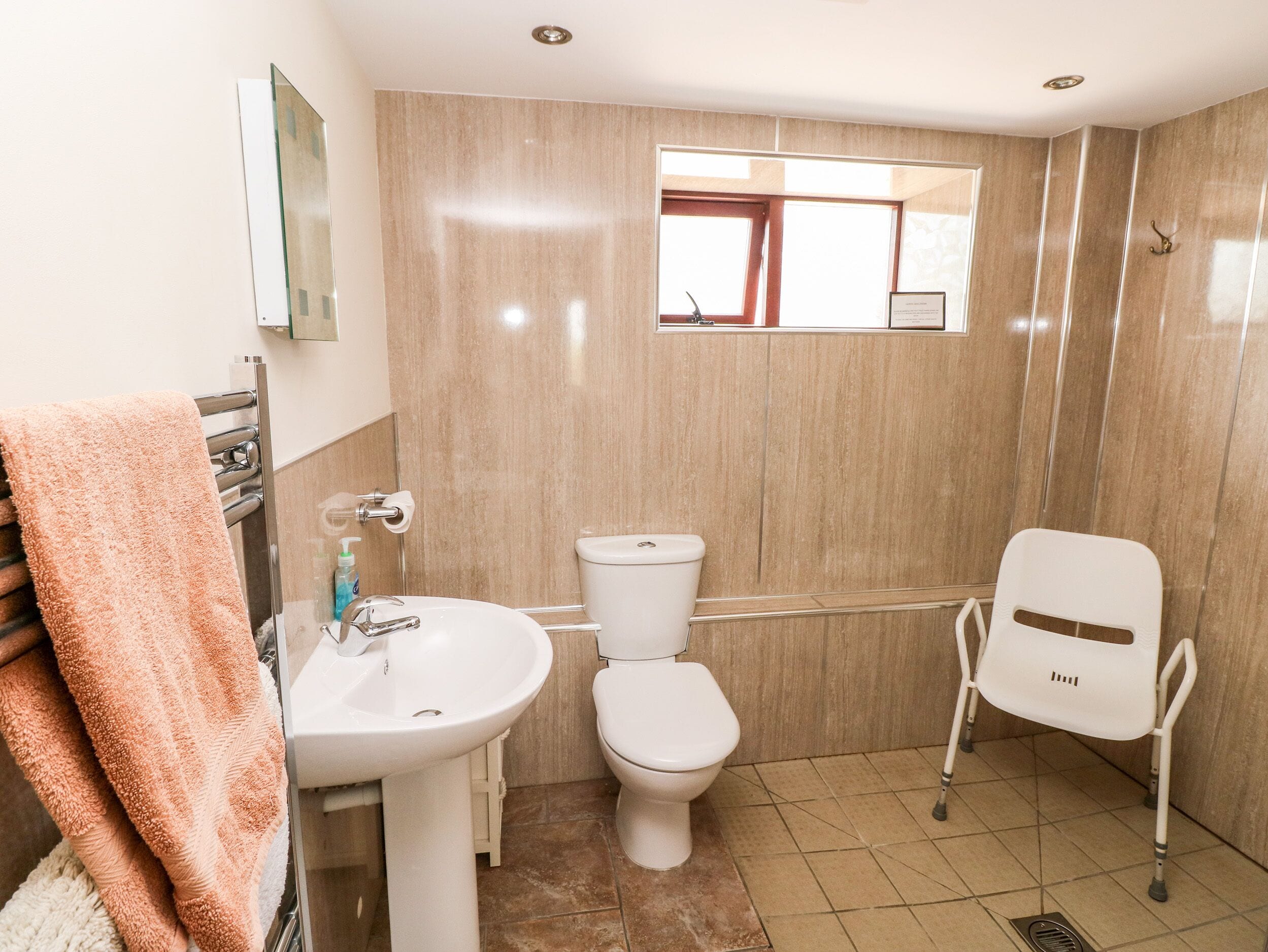 Une salle de bain avec un lavabo, des toilettes et une fenêtre.