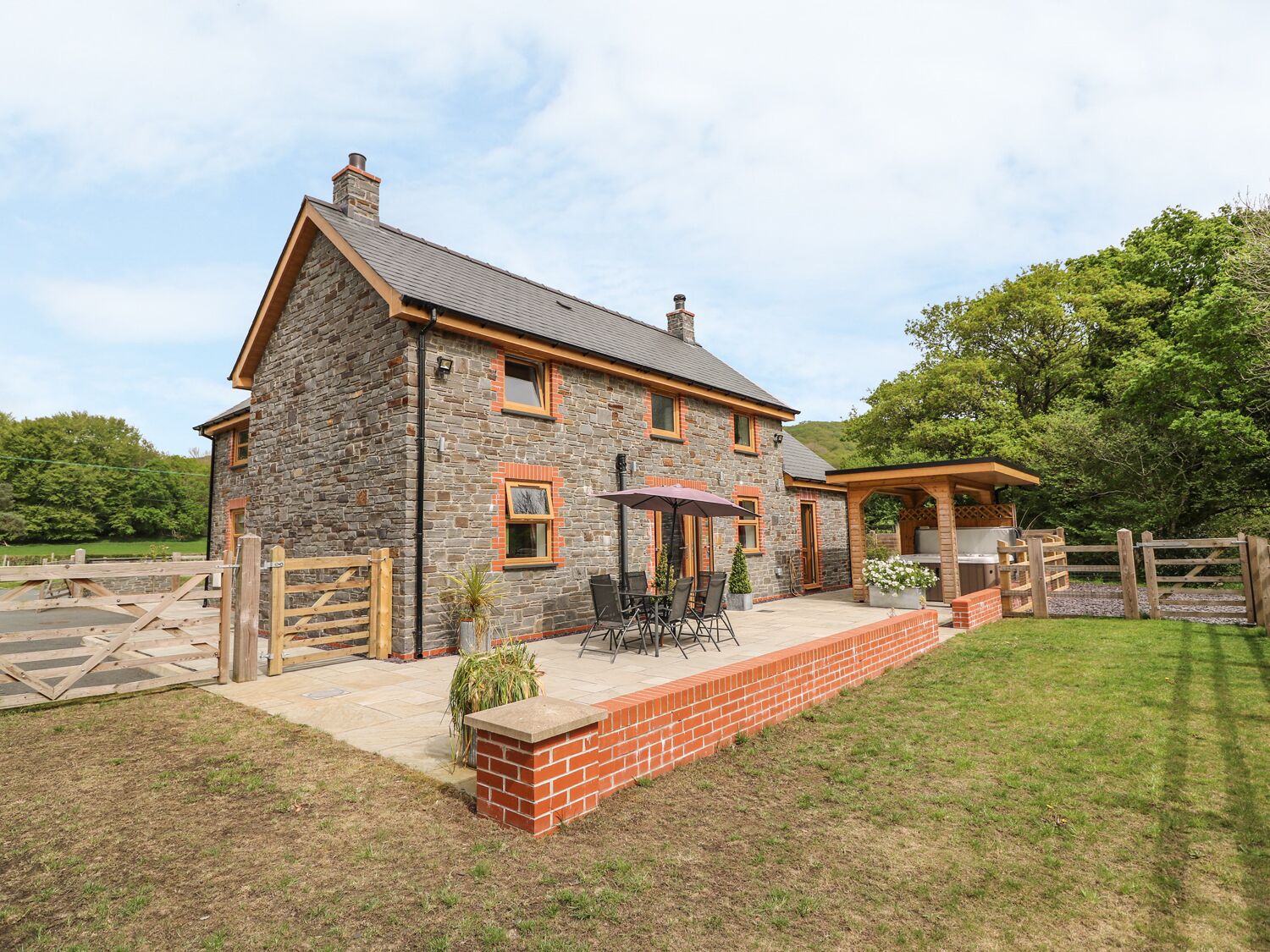 Ein Steinhaus mit Terrasse und Grillplatz.