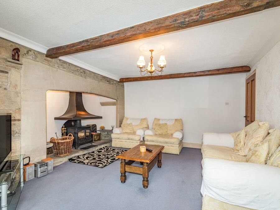 A cozy living room with a fireplace, a sofa, a coffee table, and a television.